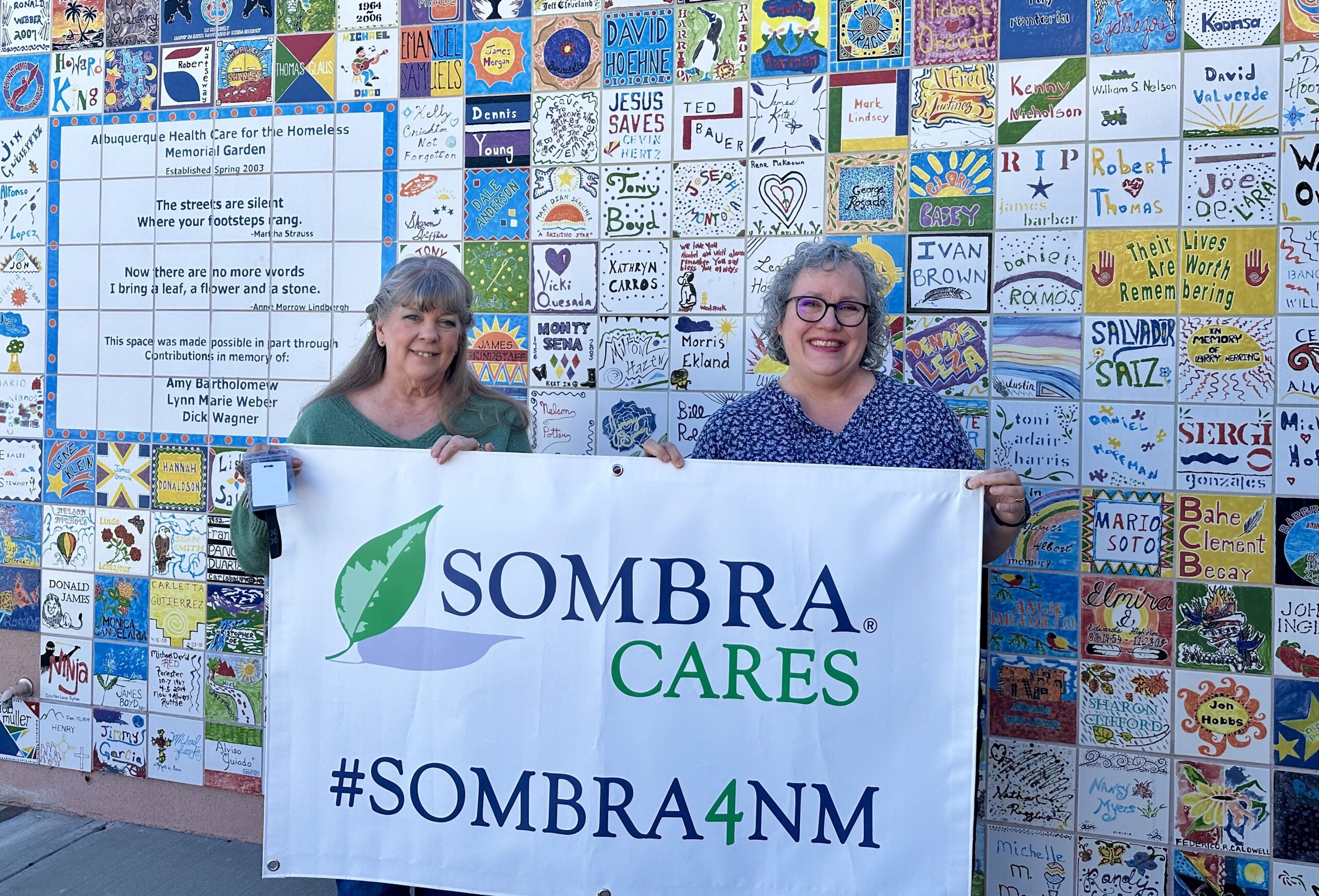 Image of two ladies holding up a Sombra Cares banner